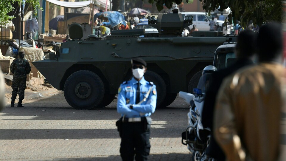 Le véhicule est placé en travers de la rue, entouré de soldats.