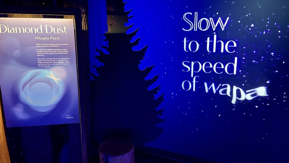 Une projection où l'on peut lire, en anglais, « Ralentissez à la vitesse de » et le mot « wapa » en stoney.