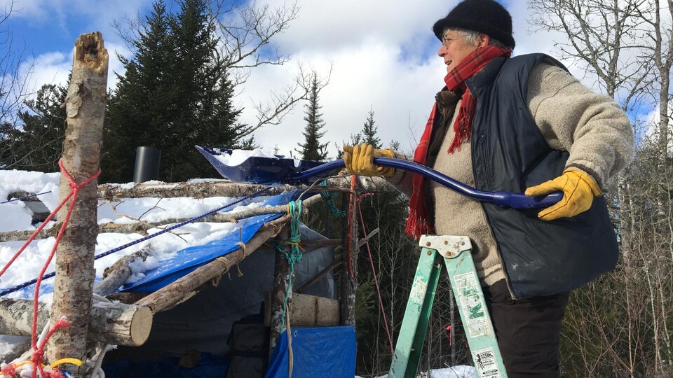 Nina Newington enlève la neige sur le toit de son abri au camp des manifestants.