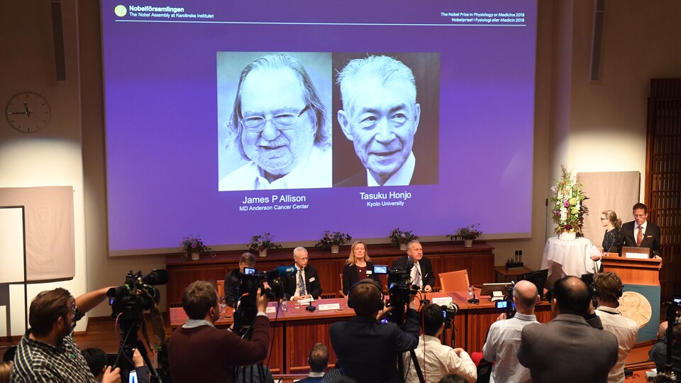 Les photos des lauréats du Nobel de médecine sont projetées sur un écran géant.