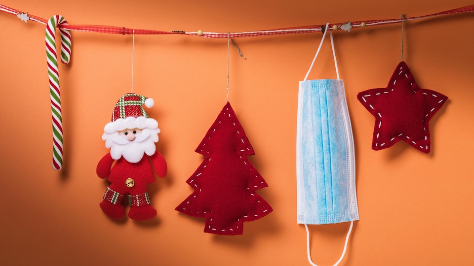 Des décorations de Noël et un masque suspendus à une corde.