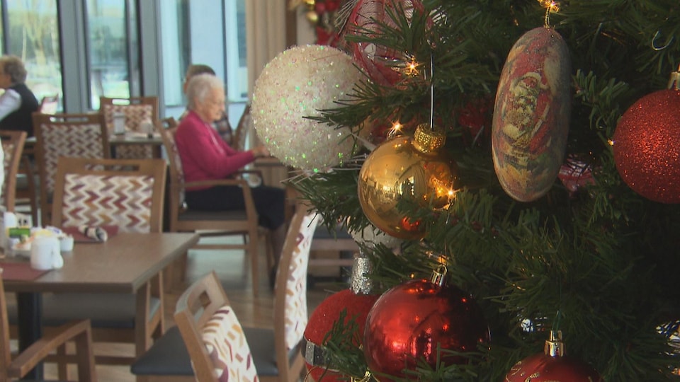 Un sapin de Noël dans une salle à manger où se trouvent des aînés.