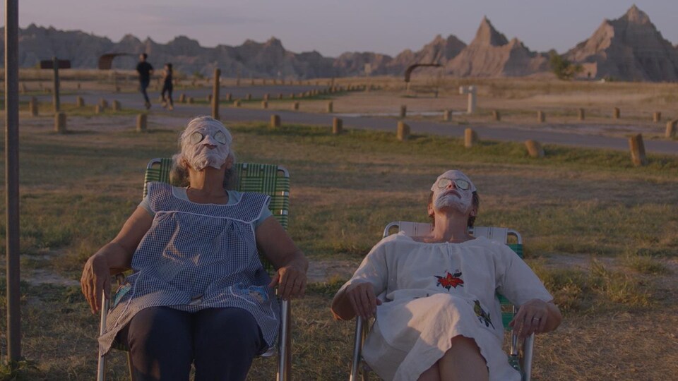 Deux femmes sont assises dehors et ont un masque de beauté sur le visage.