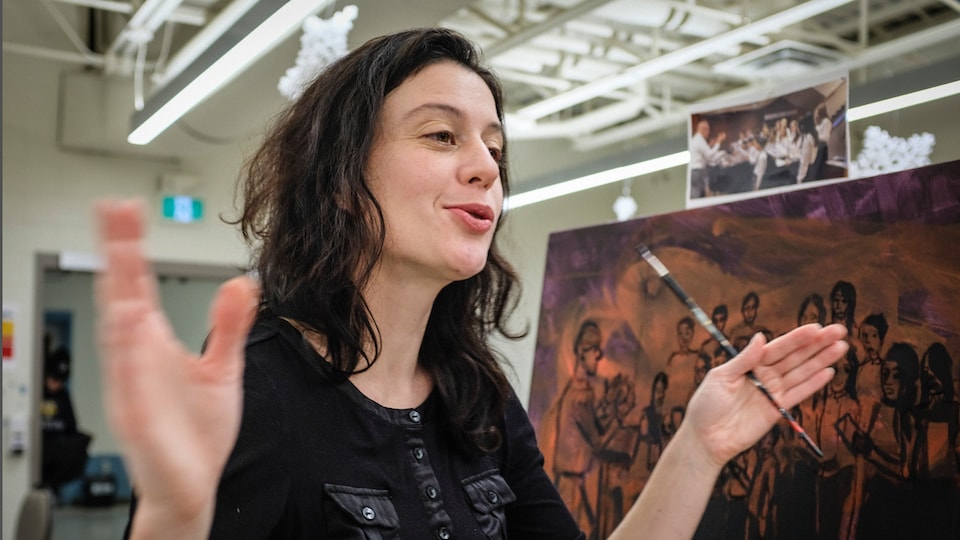 Norah Pendergast devant une toile de peinture.