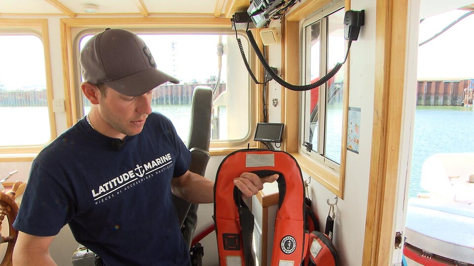 Le pêcheur Marc Doucet montre les nouveaux vêtements de flottaison à déclenchement automatique portés sur le Bicois.