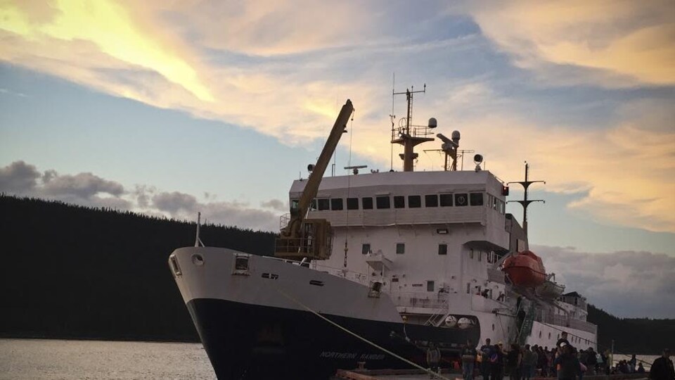 Le Northern Ranger, un bateau qui dessert les communautés du nord durant l'été, est amarré à un quai, où des passagers sont en train de descendre.
