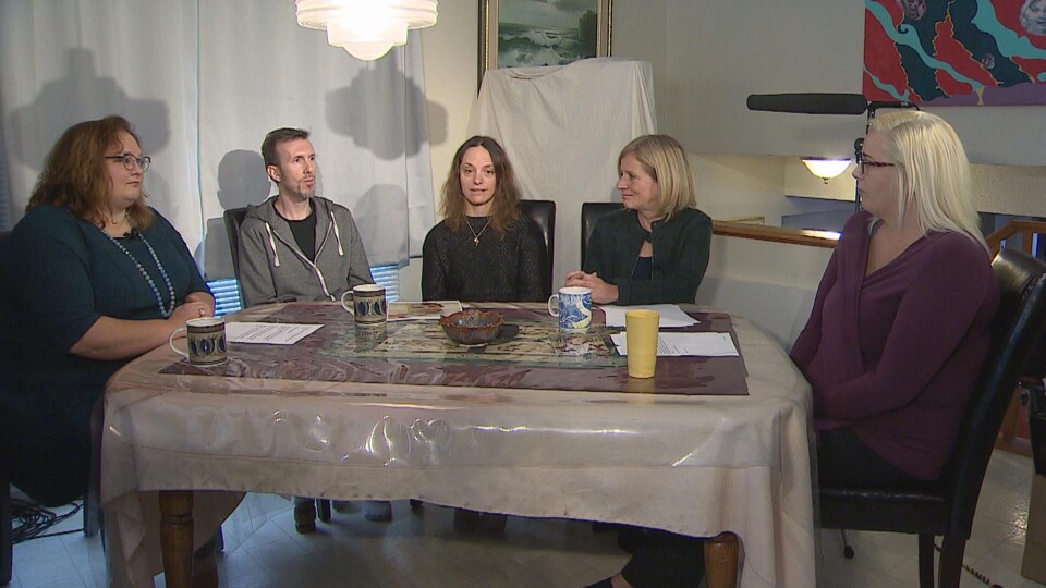 De gauche à droite : Sarah Hoffman, Philip et Michelle Baer, Rachel Notley et Colleen Wasson. Ils sont tous assis autour d'une table.