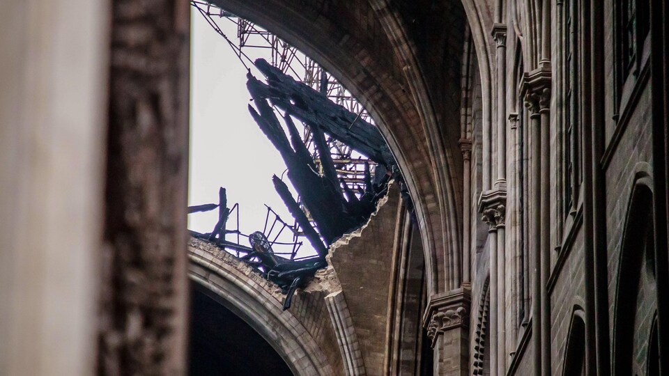 Détail du toit endommagé par le feu vu de l'intérieur, en contre-plongée