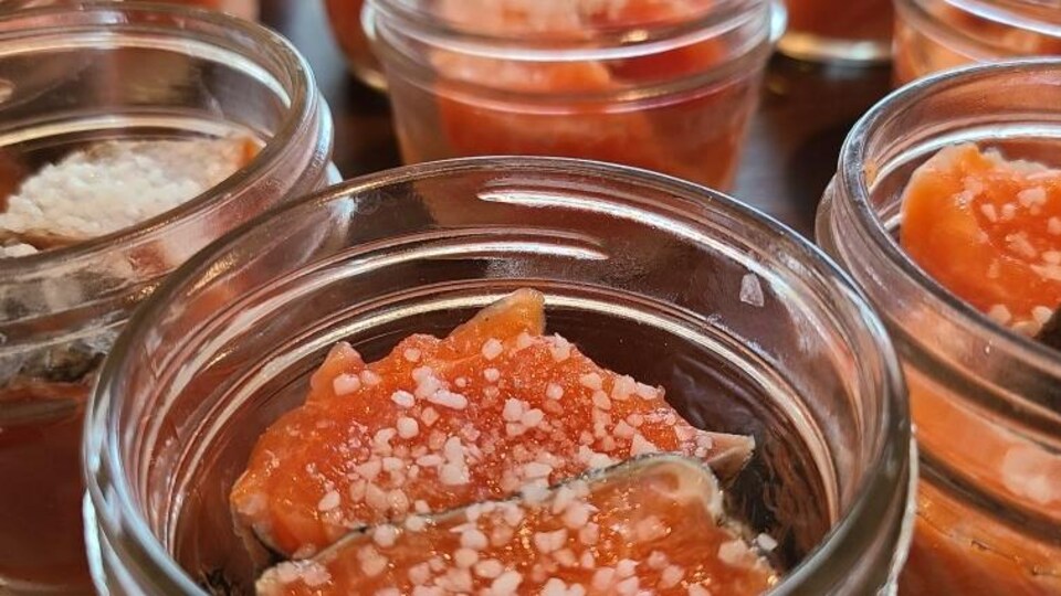 Des pots en verres qui contiennent du saumon.