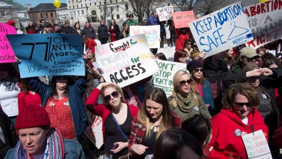 Une manifestation pro-choix : plusieurs femmes portent des pancartes.