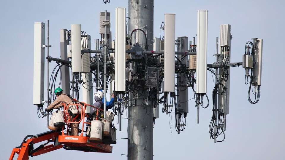 Une équipe de Verizon travaille sur une tour cellulaire pour la mettre à jour et l'adapter au nouveau réseau 5G.