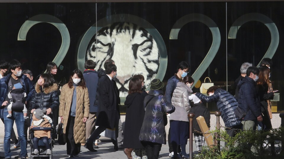 Des gens qui portent des masques dans une rue de Tokyo.