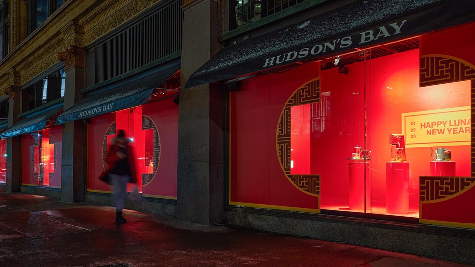 Un piéton passe devant la vitrine d'un magasin La Baie d'Hudson à Toronto.