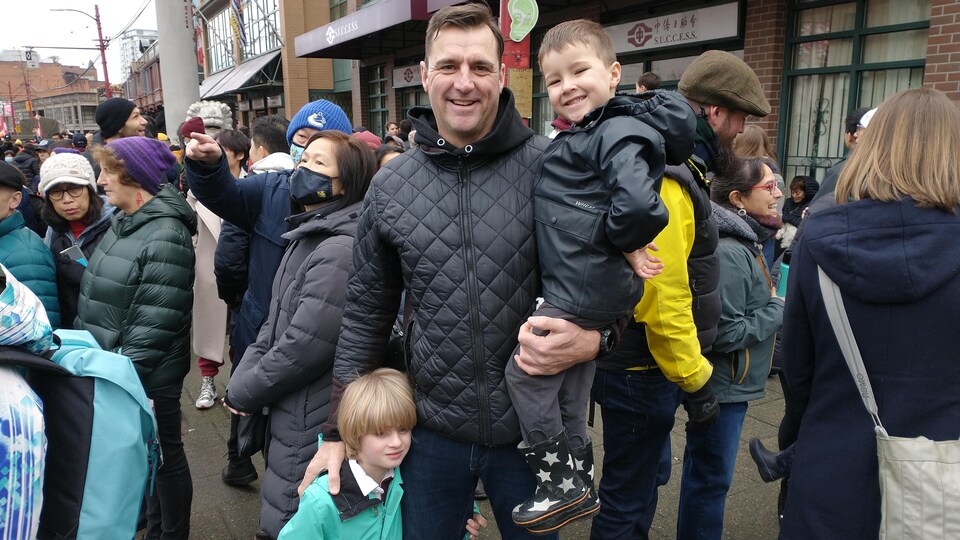 Un homme et ses deux fils au défilé du Nouvel An lunaire à Vancouver.