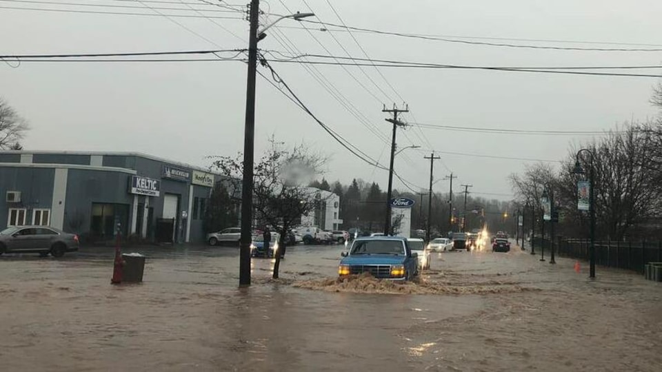 Un véhicule au coin d'une rue inondée par 90 mm d'eau de pluie.