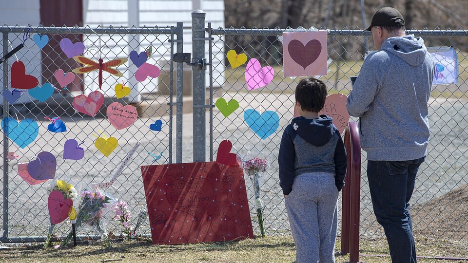 Un homme et son fils sont venus rendre hommage à Lisa McCully, qui enseignait à l'école primaire Debert, mardi. Mme McCully est l'une des 22 victimes de la tuerie de dimanche.