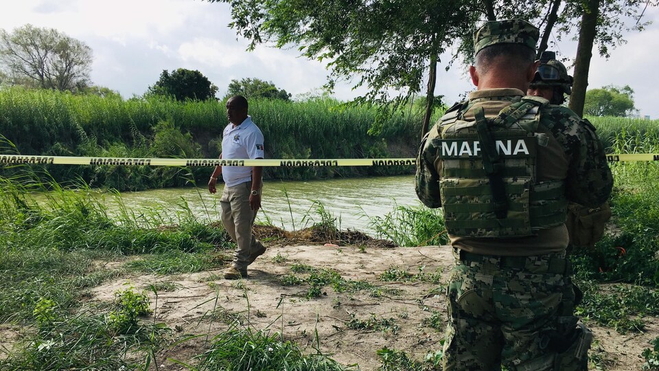 Un militaire mexicain protège le lieu où les corps ont été retrouvés.