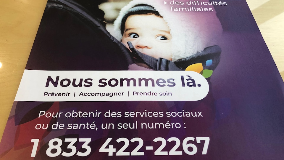 Une affiche promotionnelle de la campagne "Nous sommes là", qui indique un numéro de téléphone