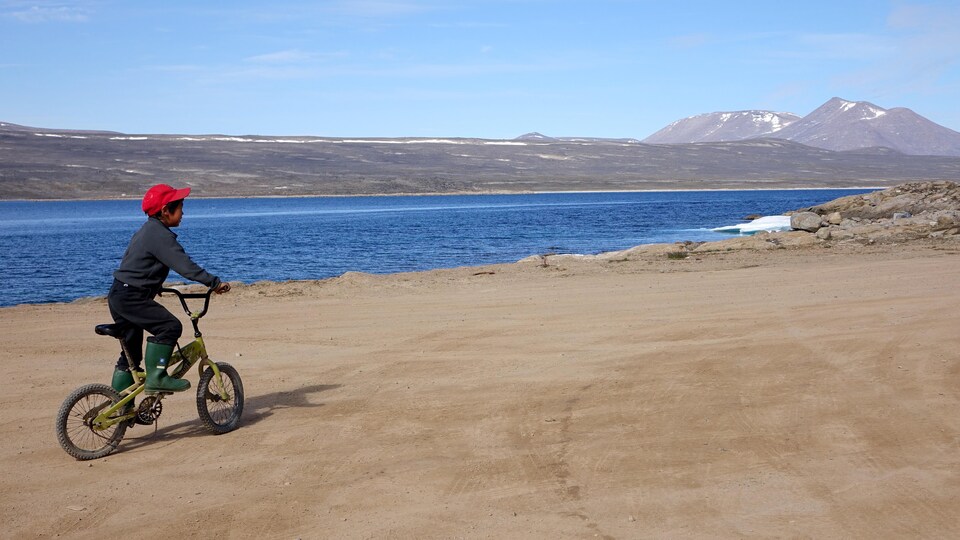 Un enfant fait de la bicyclette dans une rue de Clyde River, au Nunavut.