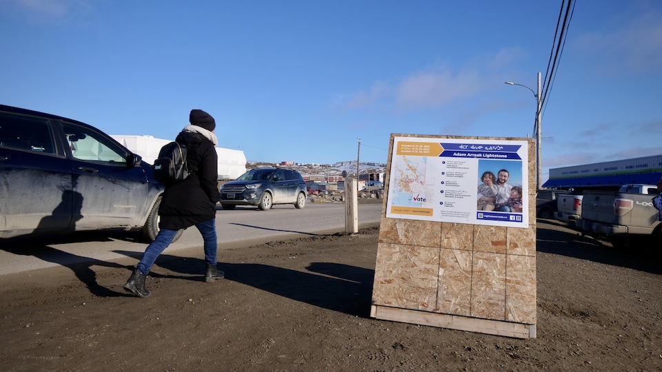 Une pancarte électorale du candidat Adam Arreak Lightstone devant une rue d'Iqaluit.