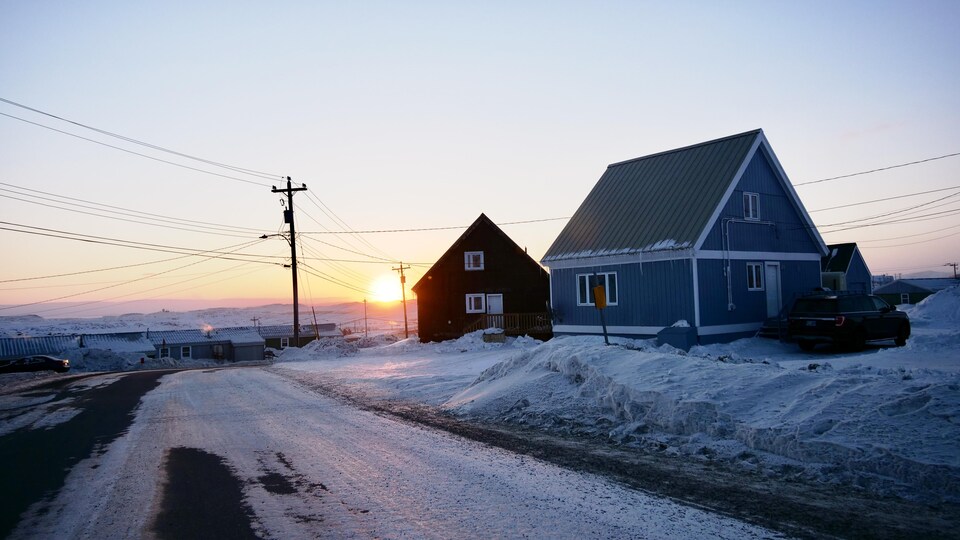 Deux maisons dans une rue enneigée d'Iqaluit durant l'hiver.