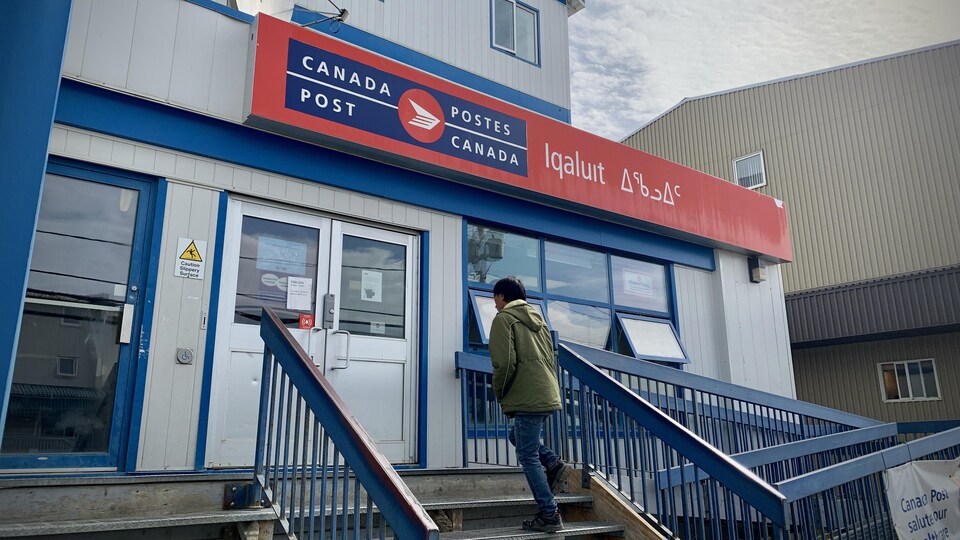 Un résident d'Iqaluit s'apprête à entrer dans le bureau de poste.