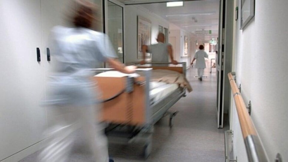 Des membres du personnel médical poussent un brancard dans les couloirs d'un hôpital.