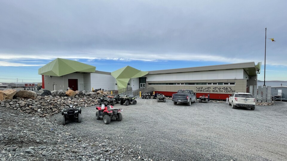 Des voitures et des quatre-roues sont stationnés devant le nouveau bâtiment du centre de santé de Sanikiluaq, en octobre 2021.