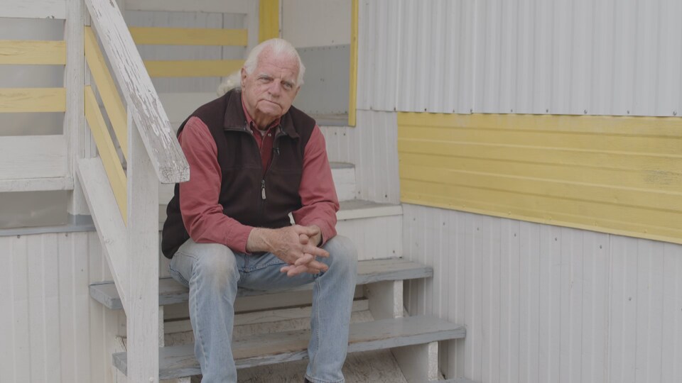 Martin O'Brien est assis sur les marches d'un escalier devant sa maison à North Ruckle. 
