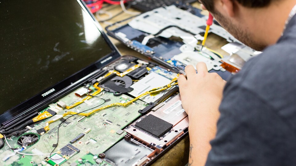 L'intérieur d'un ordinateur portable est révélé et on y aperçoit les puces et les connexions informatiques.