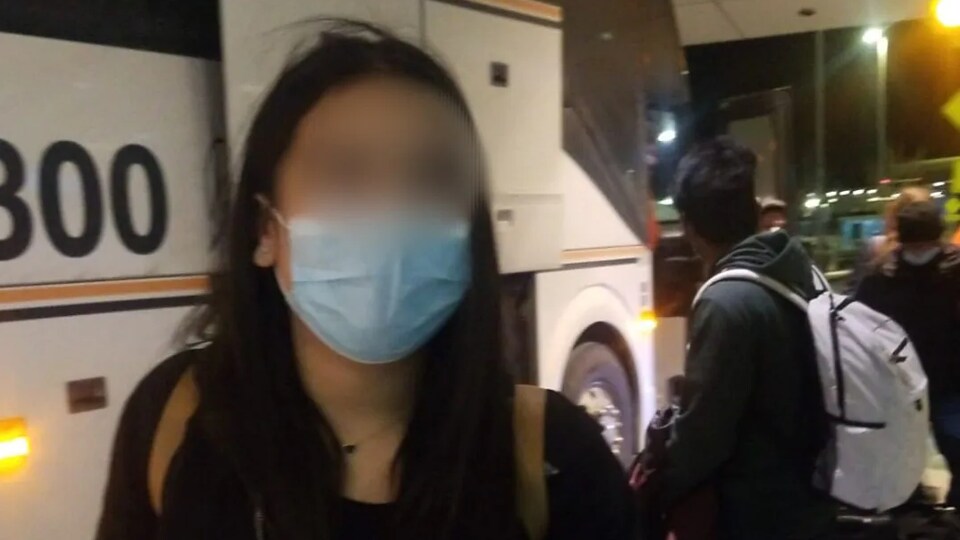 Une adolescente devant un autobus.