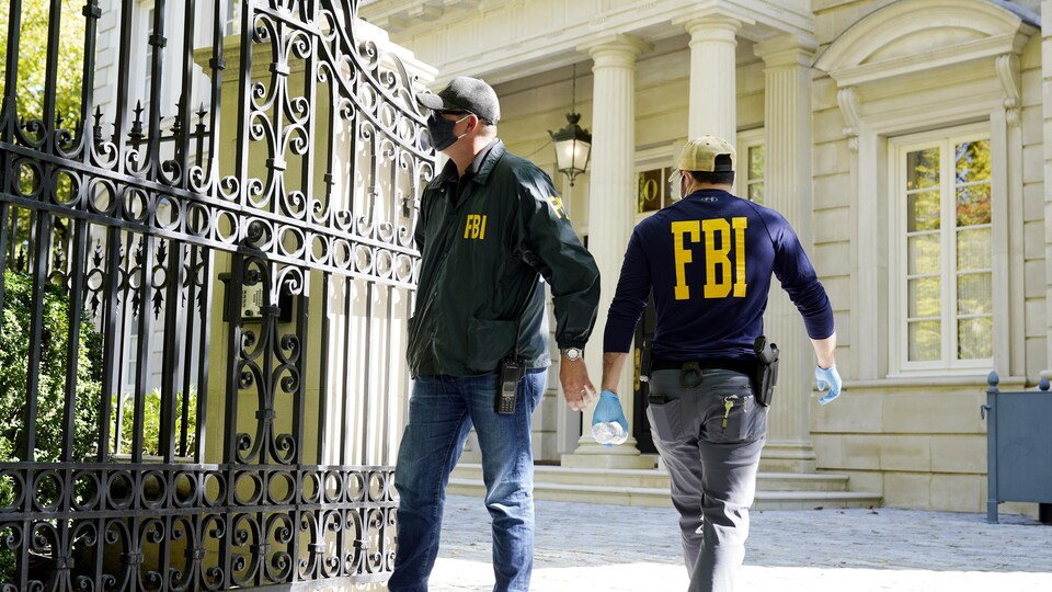 Deux agents du FBI devant une riche résidence.