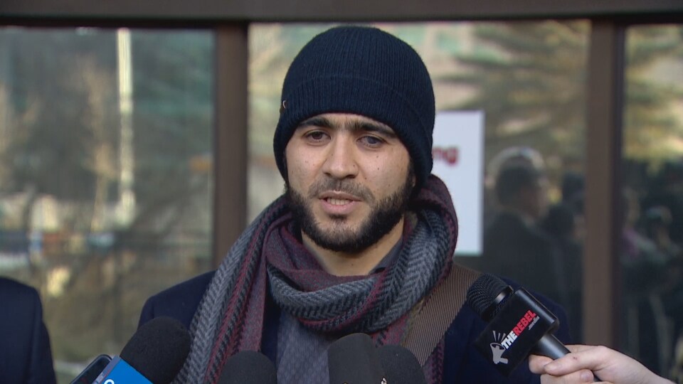 Omar KHadr porte un bonnet. Il répond aux questions des journalistes devant le tribunal d'Edmonton.