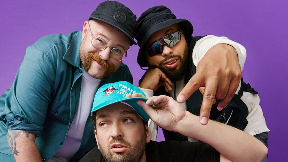 Trois hommes sur fond mauve.