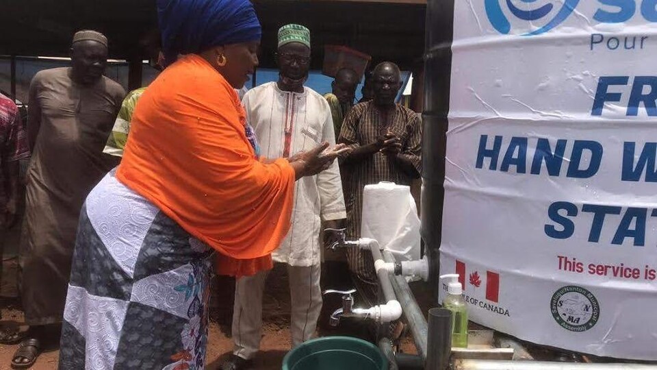 Une femme se lave les mains à une station de lavage durant la pandémie au Ghana.