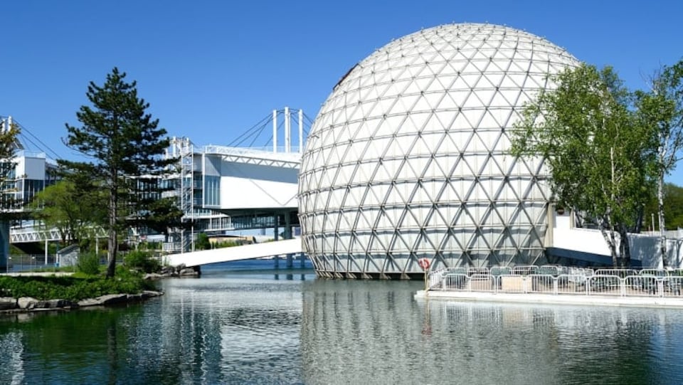 La sphère géante blanche de la Place de l'Ontario et la passerelle qui y mène au-dessus de l'eau.
