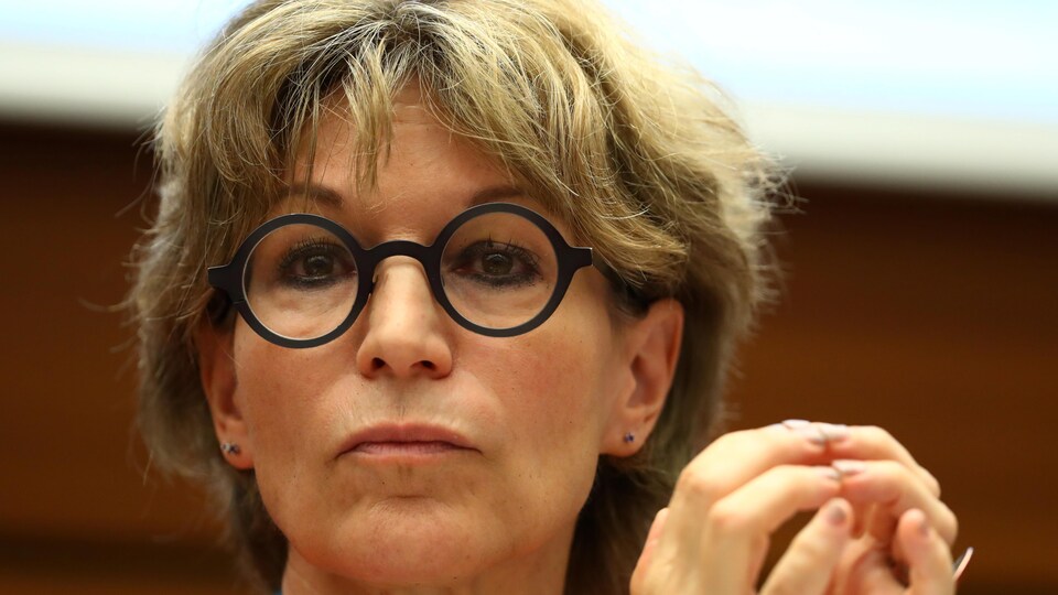 Elle joint ses mains devant son visage.