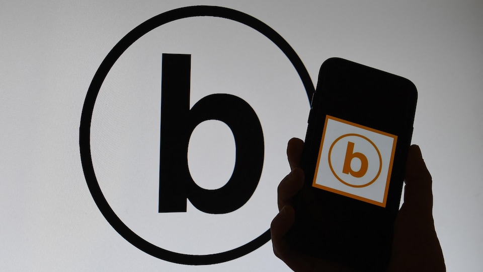Un nouveau symbole, un b minuscule à l'intérieur d'un cercle, est présenté sur un téléphone intelligent et un écran d'ordinateur. 