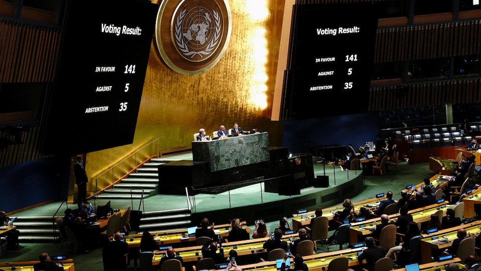 Vue d'ensemble sur l'Assemblée générale de l'ONU. Deux écrans géants affichent le résultat final du vote sur la résolution contre l'invasion de l'Ukraine par la Russie. 