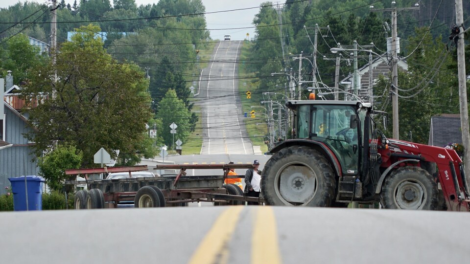 Un tracteur et une remorque sur une route.