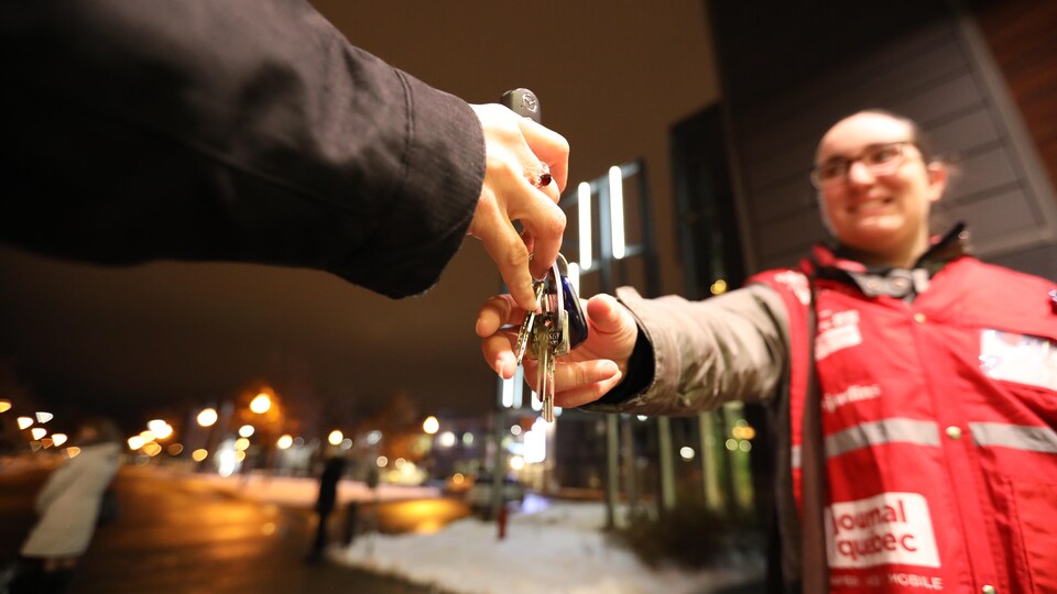 Un fêtard remet ses clés à une bénévole de l'Opération Nez rouge.