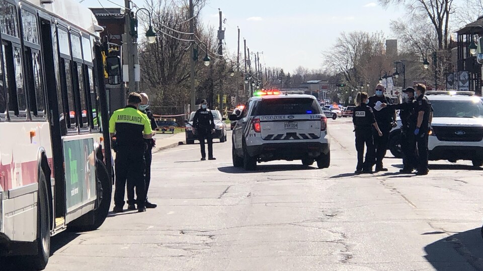 Des policiers et des ambulanciers bloquant une rue.