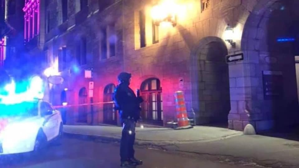 Un policier devant un immeuble.