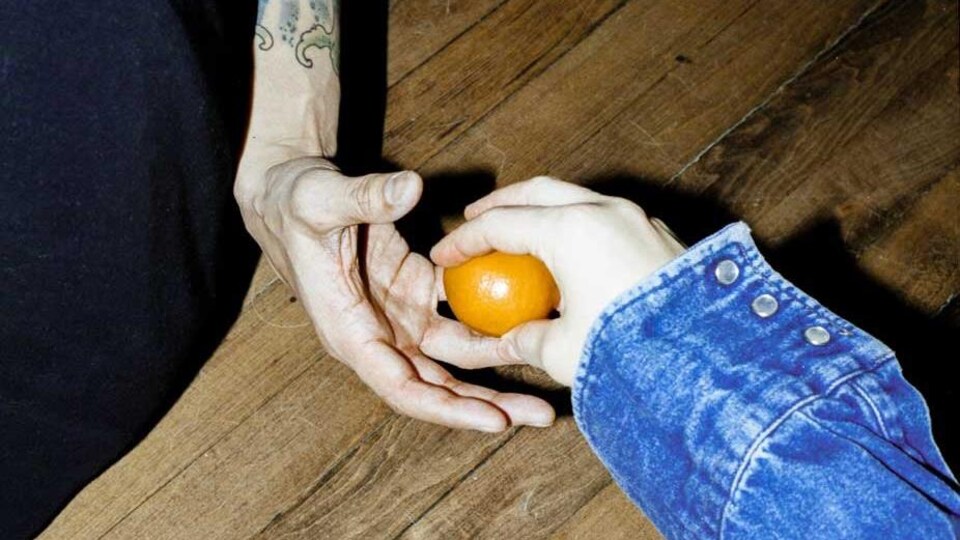 une personne passe une orange à une autre.