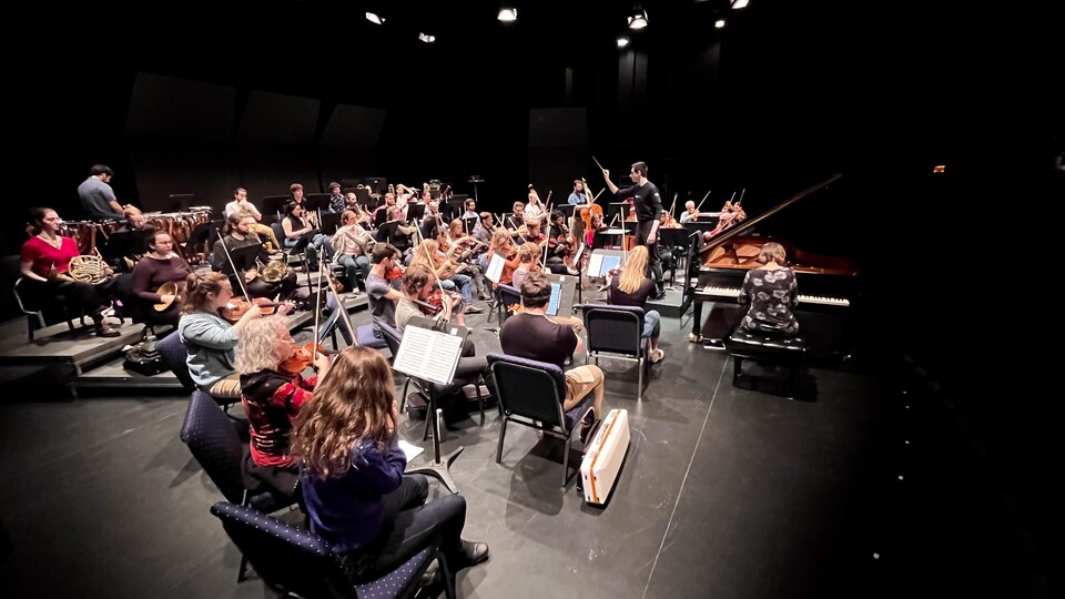 Les musiciens de l'Orchestre symphonique de la Côte-Nord en action sur scène.