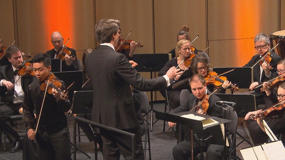 Le chef Jean-Michel Malouf dirige l'Orchestre symphonique du Saguenay-Lac-Saint-Jean pendant un concert.