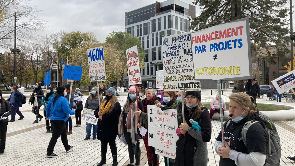 Des femmes manifestent pancarte à la main.