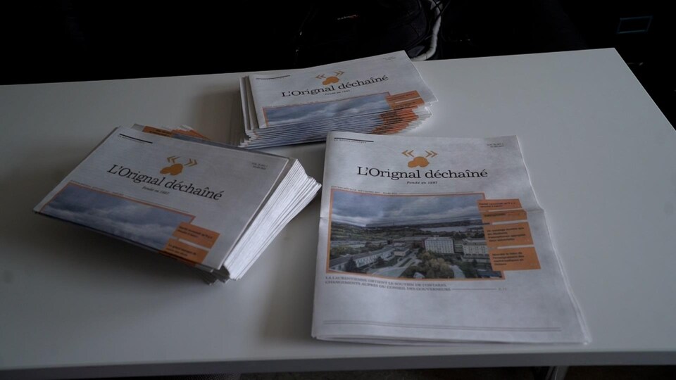 Trois piles de journaux sur une table.