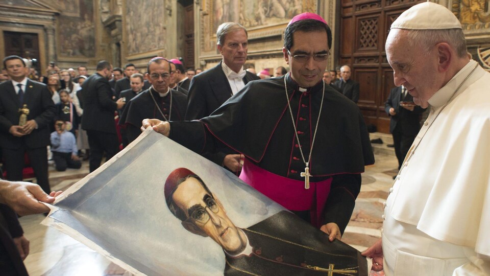 Le pape tient une photo d'Oscar Romero, qu'il regardre.