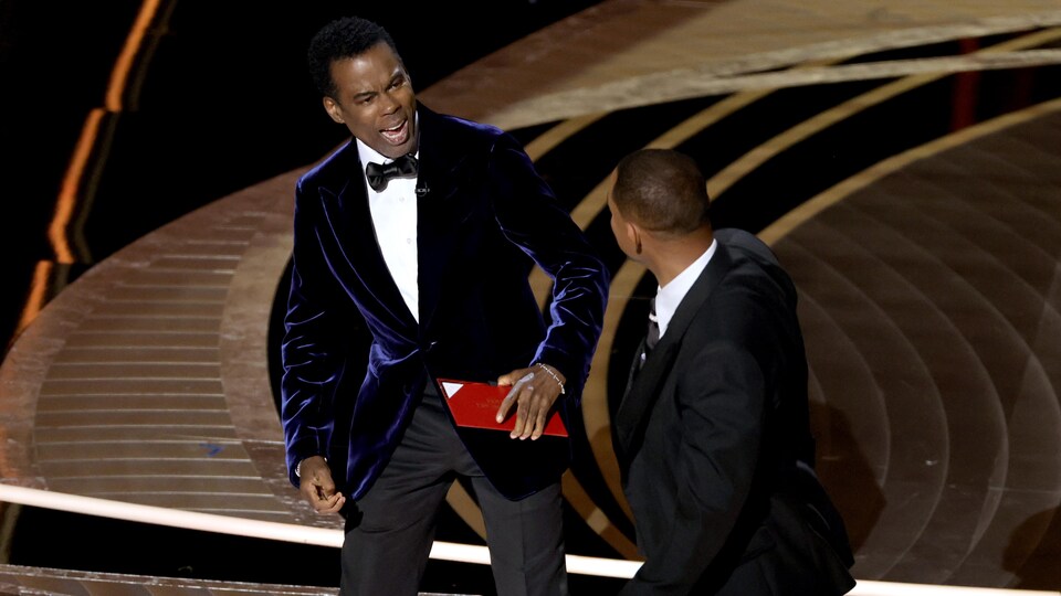 Chris Rock réagit à la gifle de Will Smith sur scène aux Oscars.
